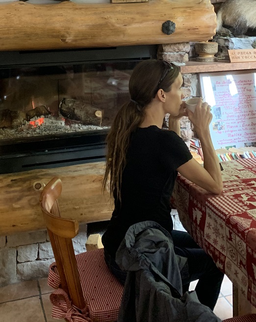 Simple Eco Mama by Fireplace Drinking Coffee