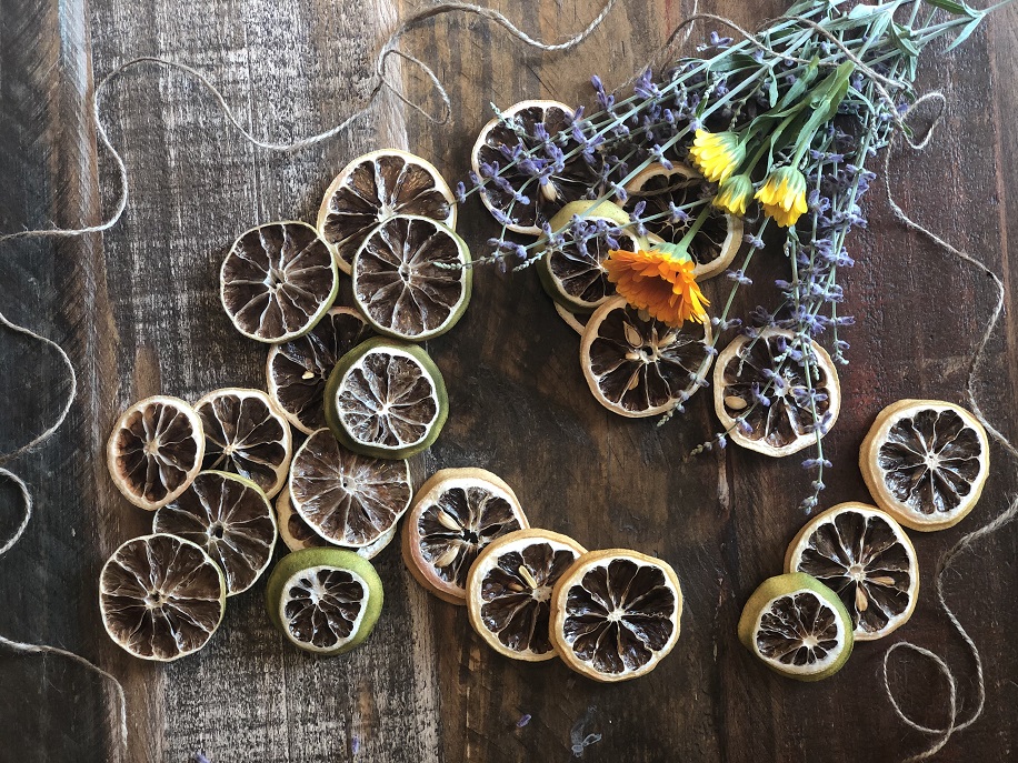 Dried lemons and limes with fresh flowers and twine